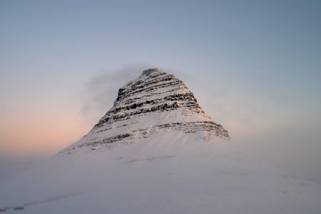 The snow-capped top of Mount Kirkjufell at sunrise