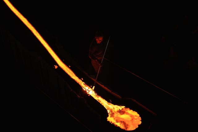 A stream of lava is flowing down in a dark room during the Lava Show
