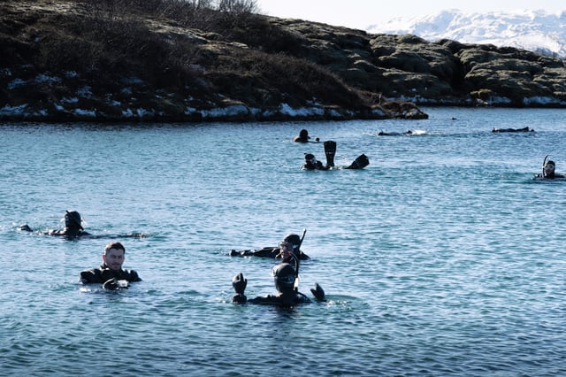 People are snorkeling in dry suit in the clearest waters in the world in Silfra in the National Park of Þingvellir
