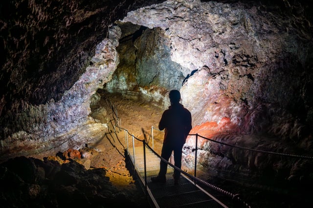 People underground exploring an old lava cave
