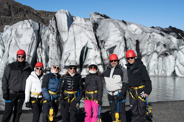 A whole family, all smiling and geared up for their glacier hike on Sólheimajökull