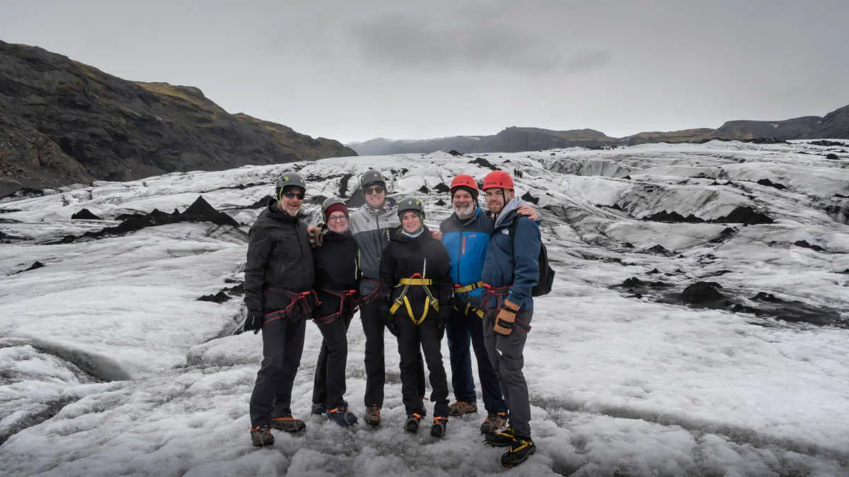 Une famille de 6 pose pour la photo, sur un glacier