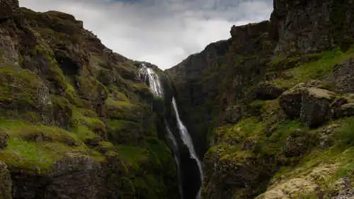 Deux personnes regardent une magnifique chute d'eau