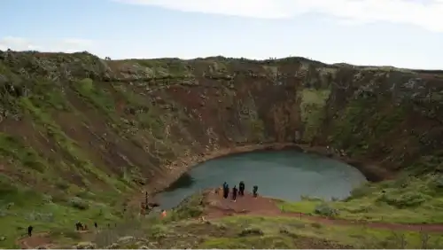 Un cratère volcanique rouge avec un lac turquoise au fond