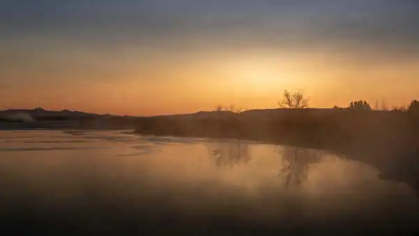 Coucher de soleil par delà un lac gelé