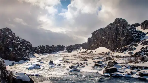 Winterscape of a canyon, with a flowing river in the middle