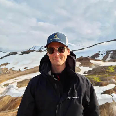 guide smiling at the camera with arm crossed, in the winter