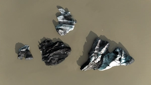 Icebergs reflecting in the water of the glacier lake of Sólheimajökull