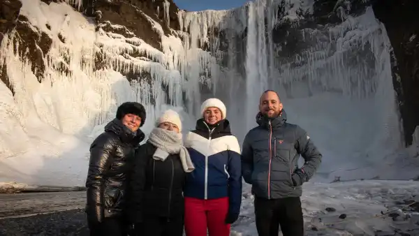 Someone is kneeling in front of his wife, offering her a block of ice