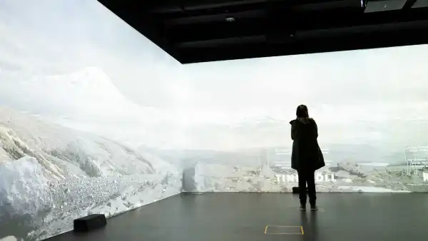 Someone is standing in front of a wall-wide interactive display