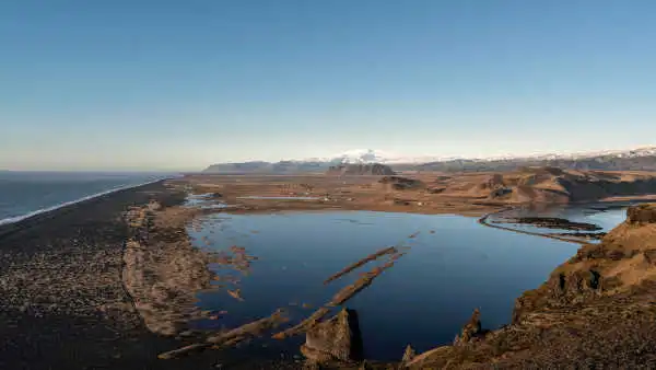 Panorama of lake, black sand beach and glaciers