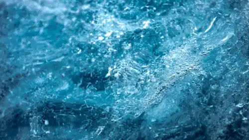 Close up on a blue wall of ice in an ice cave. Many shades of blue and air bubbles trapped inside the ice