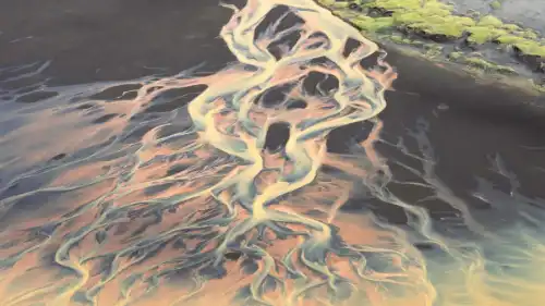 A yellow river is flowing down with braided patterns