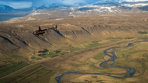 Helicopter flying over Iceland's waterfalls and volcanic craters
