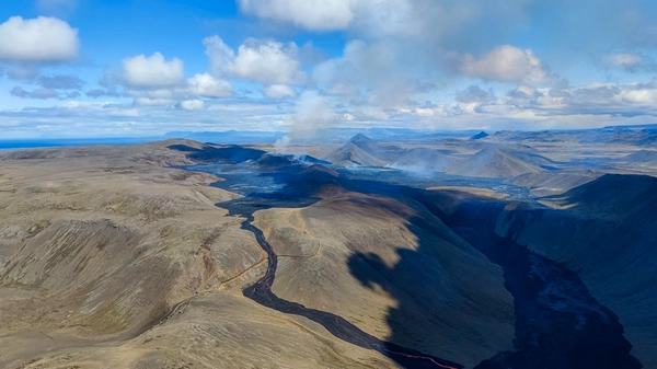 Helicopter flying over active volcanic eruption with lava flows