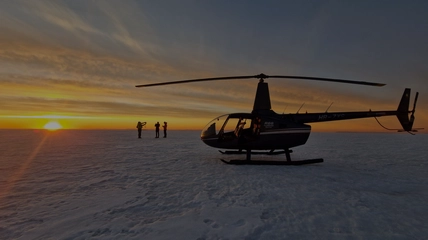 Aerial view of helicopter approaching glacier landing site