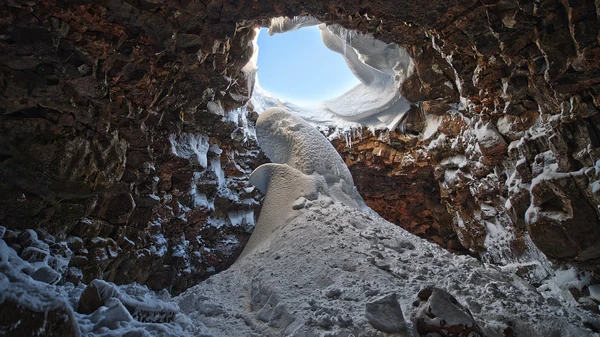 Guide explaining lava tube formation to visitor group