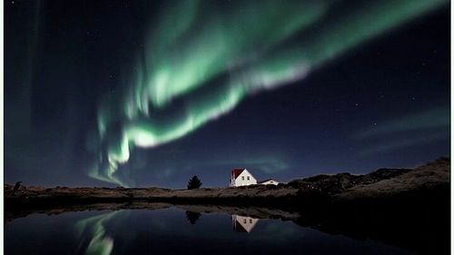 Spectacular Northern Lights aurora dancing over Icelandic landscape with small group viewing