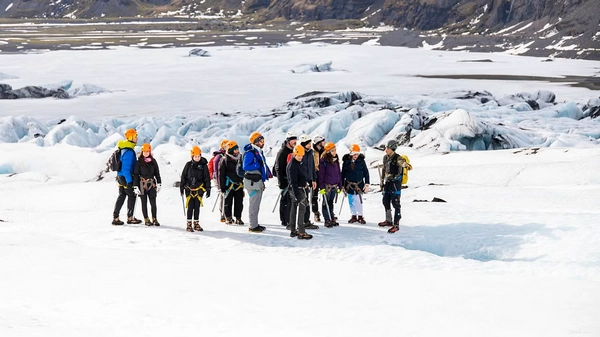 Close-up of crampons on glacier ice with crevasse in background