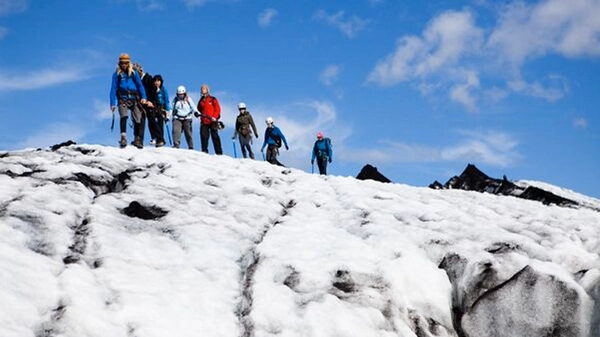 Glacier guide explaining ice formations to hiking group