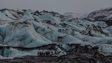Group of glacier hikers walking on Sólheimajökull with guide