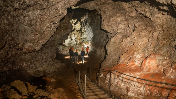 Visitors exploring the ancient lava tube formations in Vatnshellir Cave