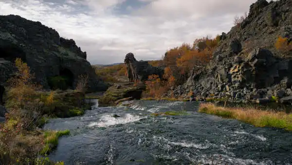 A torrent flows down amid volcanic cliffs