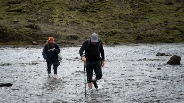 Two customers are crossing a river by walk