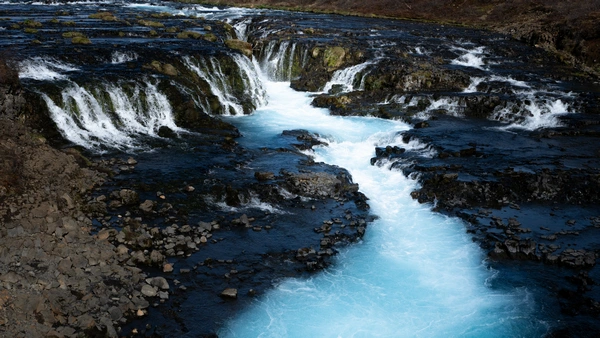 A beautiful waterfall is falling in a turquoise blue river