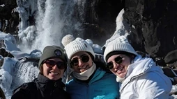 Happy clients smiling in front of the Öxarárfoss waterfall