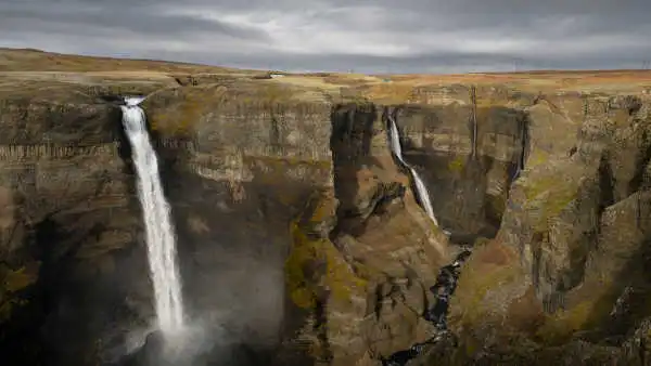 Two gigantic waterfalls falling into an immense canyon