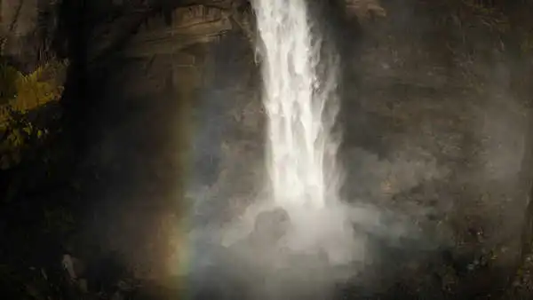 CloseUp of the tip of a waterfall with a rainbow on the left side