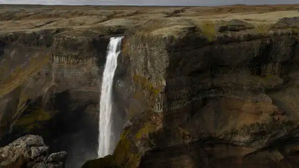 A high waterfall falls into a canyon