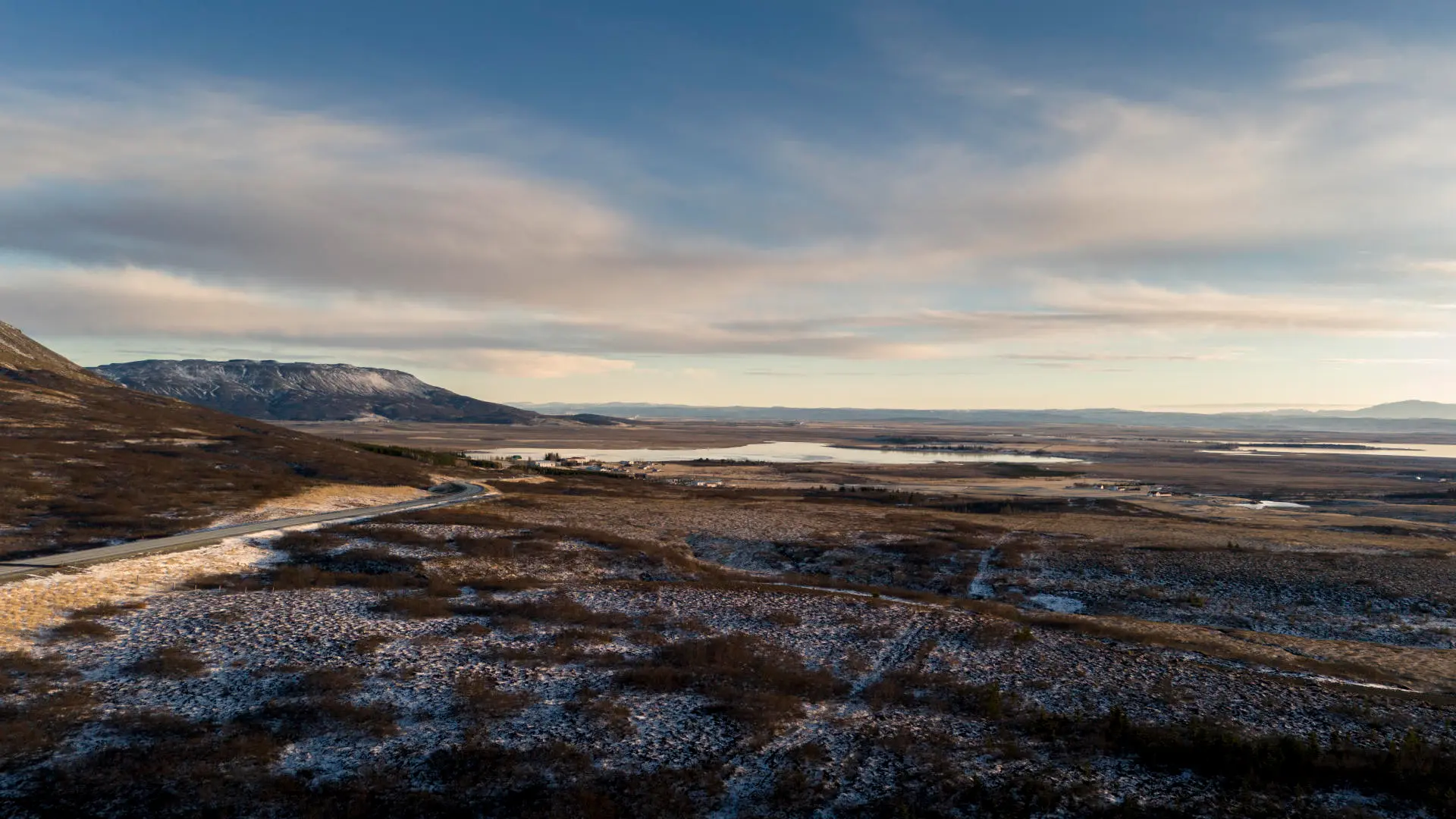 A drone view of a landscape with mountains and lakes