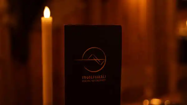 Restaurant menu with a candle in the back