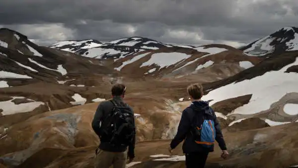 Two hikers are staring at the ever steaming valley in front of them