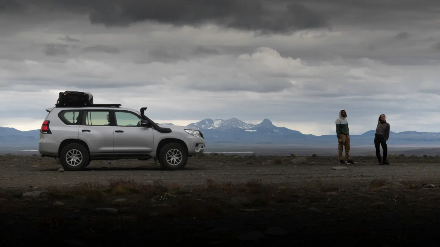 Our modified, lifted Toyota Land Cruiser sitting in the wilderness with two happy clients next to it