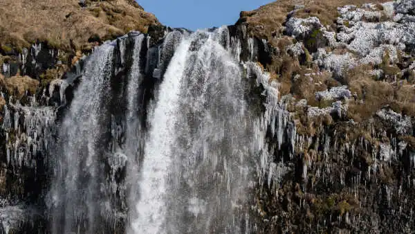 Closeup of the top of a partially frozen waterfall