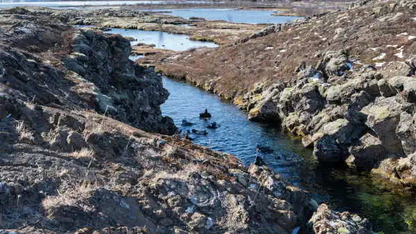 People are snorkeling in a tectonic fissure