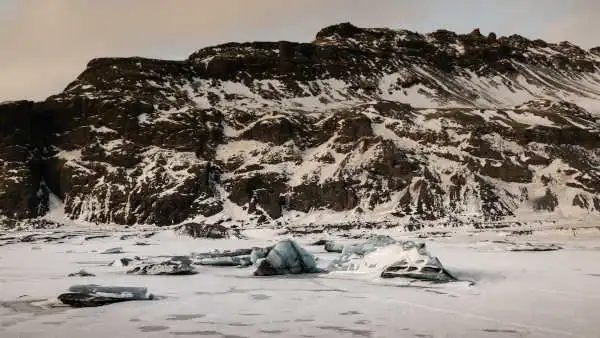 Frozen glacier lake and icebergs at sunset