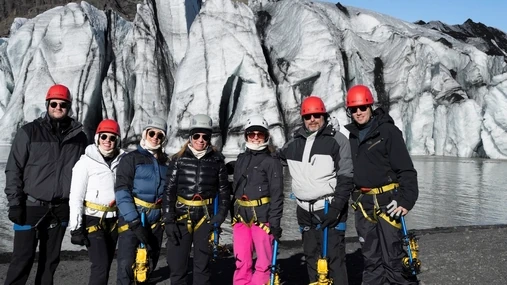 A whole family, all smiling and geared up for their glacier hike on Sólheimajökull