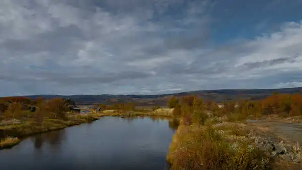 Autumnal landscape with a river and a wooden bridge