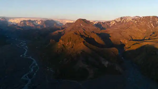 Sunset over a green valley with swirling rivers in its bed