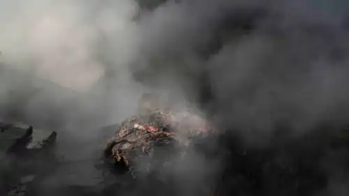 A dense cloud of steam is barely hiding a vividly red rock